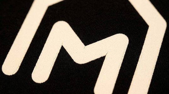 Makroaufnahme eines Siebdrucks auf schwarzem Textil